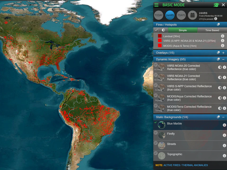 Satellite map of North and South America covered with red fire and hotspot markers, with a control panel showing fire data layers and map overlay options.